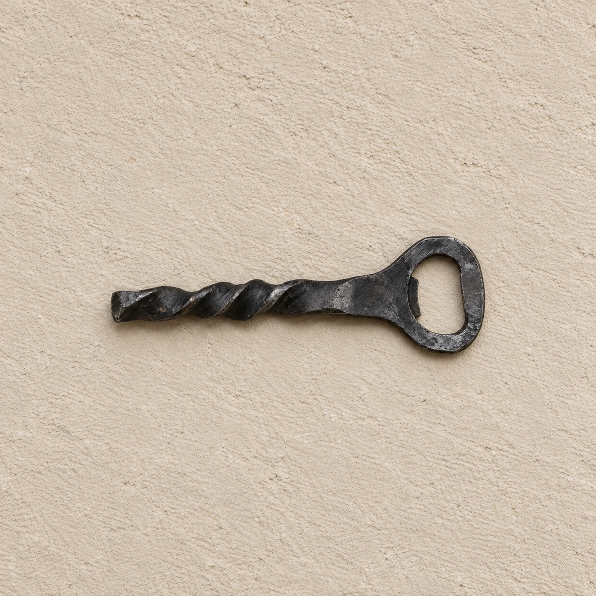 Handgeschmiedeter Flaschenöffner aus dunklem Eisen mit gedrehtem Griff